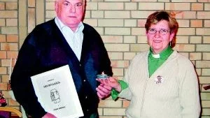 Svend Berendt med den dokumentation som han kallat Min ryggsäck. Ingela Astvall överlämnar ett Taizéljus som minne av besöket i Gamleby.