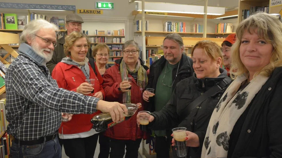 Finskt firande. Det var det på Enebys bibliotek, när finska bokavdelningen invigdes. Chefen Jan Persson häller upp julmust, till de närvarande. Till höger Raija Arvidsson från Norrköpings kommun.
