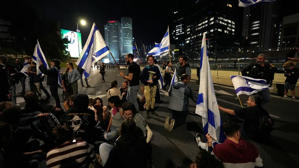 Israeler blockerar en motorväg utanför Tel Aviv i protest mot regeringens förslag att ändra rättsväsendet.