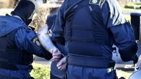 En av de gripna HA-männen förs bort av polis efter razzian i Piteå den 23 oktober. I dag inleds rättegången mot fem män, två av dem från Piteå. (Arkivbild)