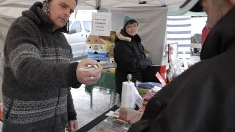 Marknadsknallen Curre Bergström, Piteå, visar en av sina handgjorda bruksknivar för en intresserad kund.