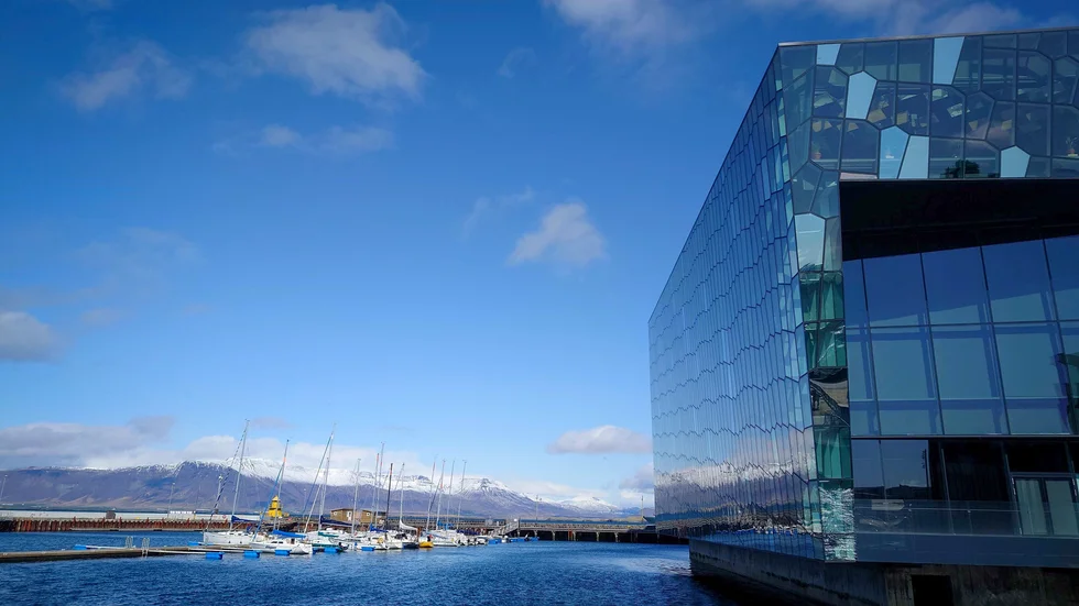 Toppmötesdeltagarna får utsikt över snötäckta fjäll från den pampiga möteslokalen Harpa i centrala Reykjavik.