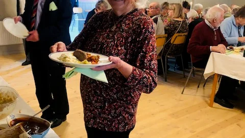 Anna-Greta väljer buffens läckerheter och Göran väntar på sin tur