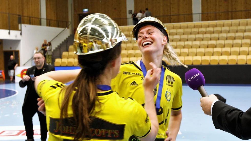 Nina Koppang kramas om av Mai Kragballe Nielsen samtidigt som hon blir intervjuad av C mores reporter.