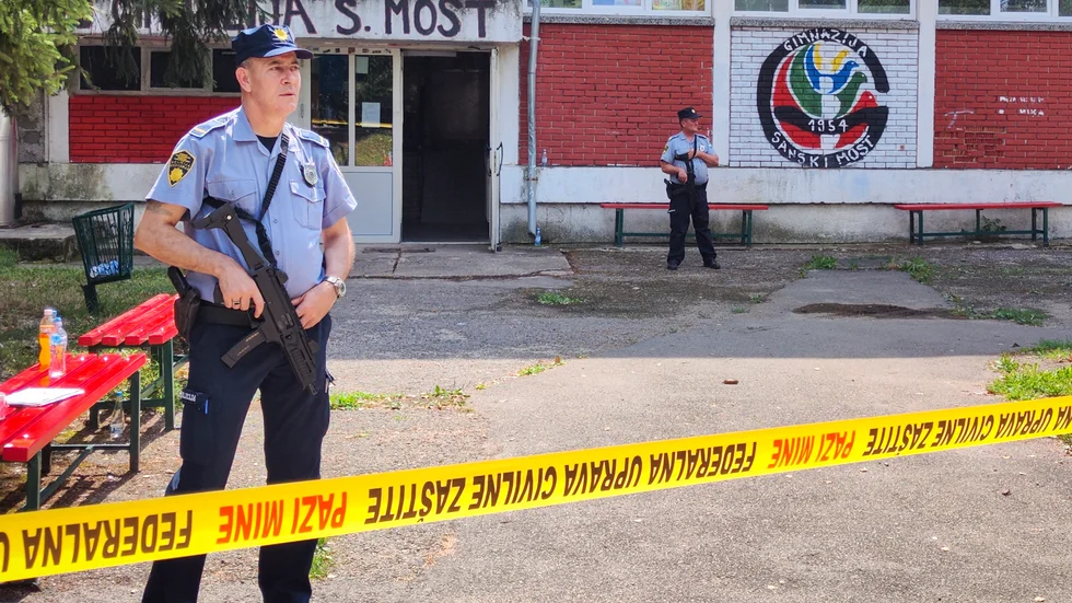 Poliser bakom avspärrningar på skolan i Sanski Most, Bosnien-Hercegovina, där flera personer sköts ihjäl på onsdagsmorgonen.
