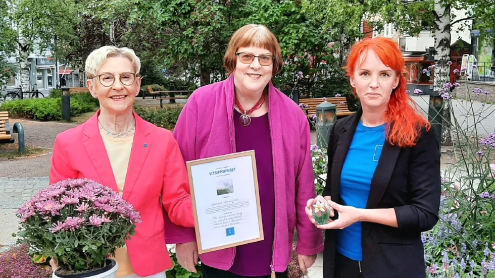Helén Lindbäck, gruppledare för KD och Malin Viklund, ordförande delar ut Vitsippspriset till Harriet Gardebjörk, i mitten på fotot.
