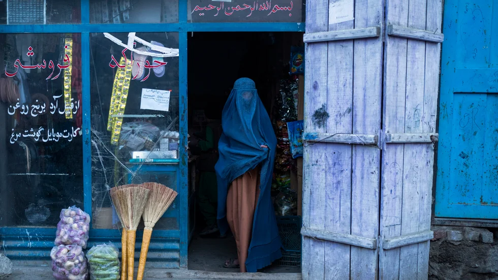 En afghanska kvinna, klädd i heltäckande burka, går ut ur en butik i huvudstaden Kabul. Arkivbild.