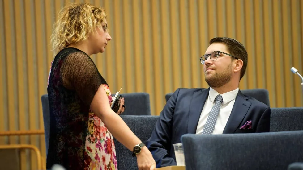 Paula Bieler i samspråk med partiledaren Jimmie Åkesson i riksdagen. I sommar har Bieler befunnit sig på hetare platser än så.
