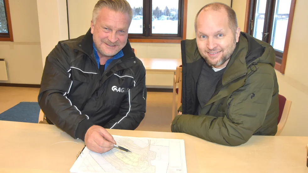 Initiativtagaren Håkan Holmberg (t v) tittar på en karta över Björnsholmens Marina och diskuterar med mäklaren Fredrik Wikström.