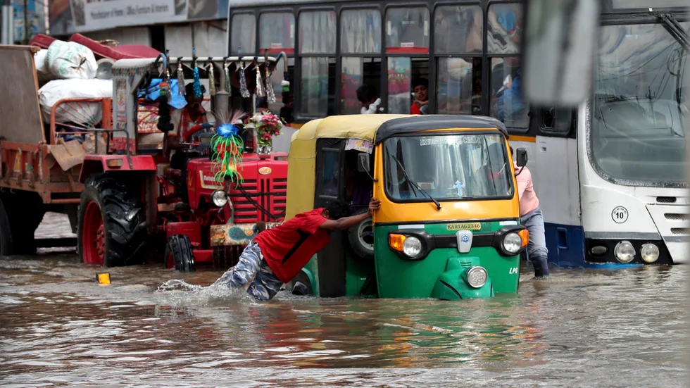 En motordriven riksha knuffas fram genom en översvämmad gata i indiska Bangalore.