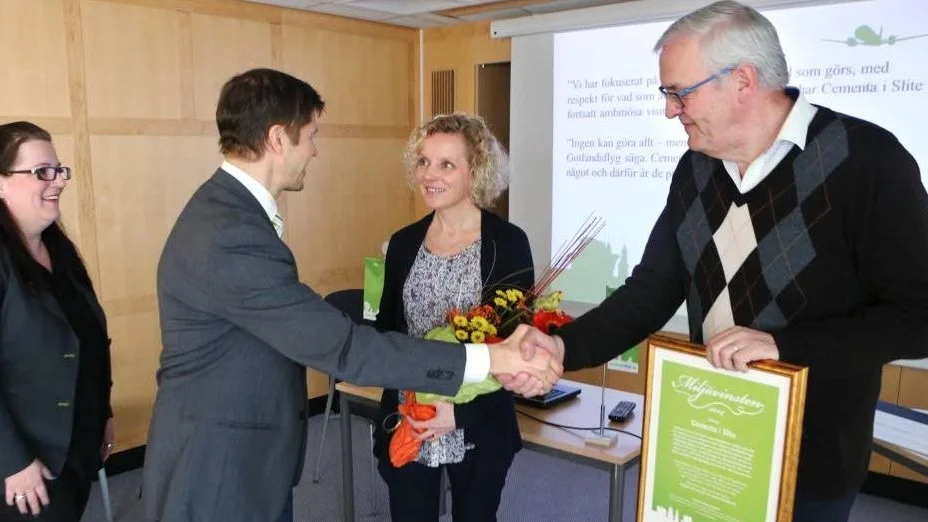 Ola Mattsson, vd Gotlandsflyg överräcker blommor och en check på 10 000 kronor till Kerstin Nyberg och Gunnar Ahlquist från Cementa.