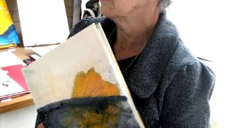 Angela Brignone Duckert med en av sina välgjorda böcker där hennes grafik samsas med Adonis poesi.