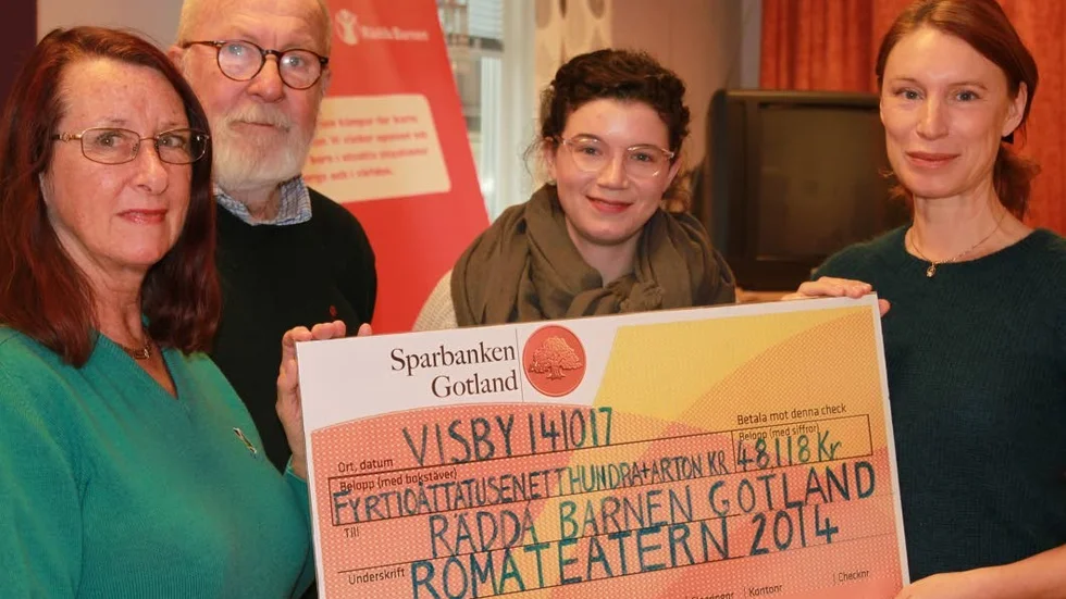 Rädda barnen tar emot checken med pengar som Romateatern har samlat in under sommarföretsällningarna 2014