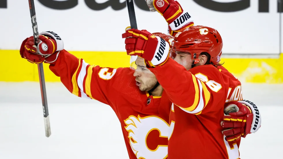 Calgarys Elias Lindholm, till höger, firar sitt mål med Johnny Gaudreau i första Stanley Cup-matchen mot Dallas.