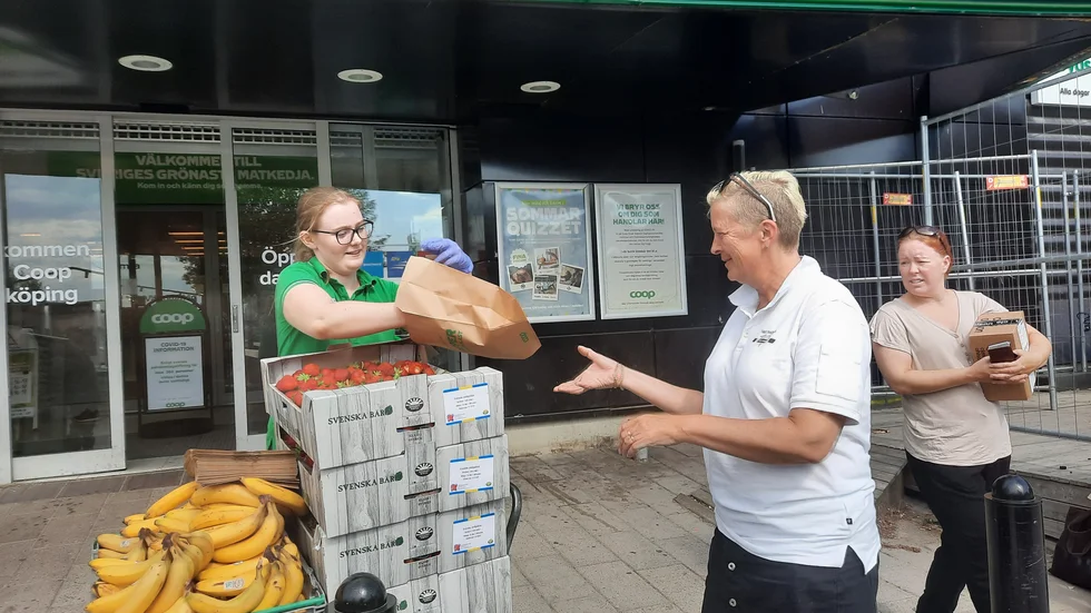 Coop-medarbetaren Hanna Sjödin delar ut jordgubbar till de butiksbesökare som tvingas vända i dörren. 