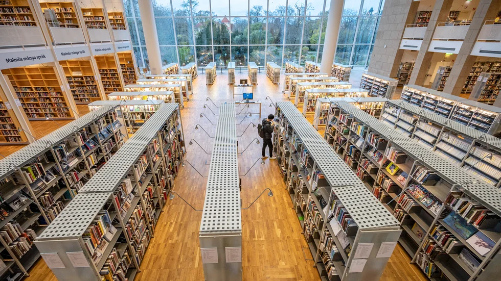Enstaka besökare och en coronasäkrad informationsdisk på Malmö stadsbibliotek. Arkivbild.