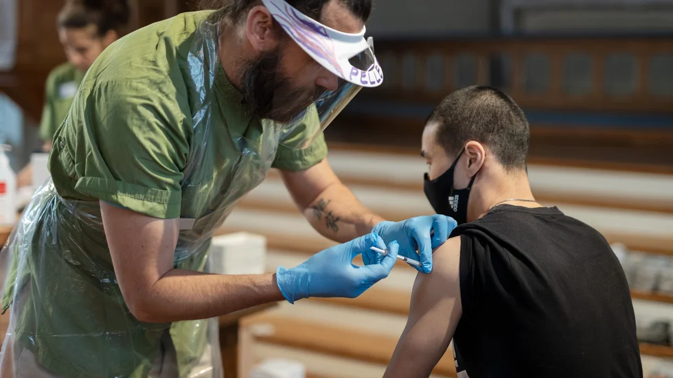 Sjuksköterska Pelle Lörelius vaccinerar André Wikström med den första dosen.