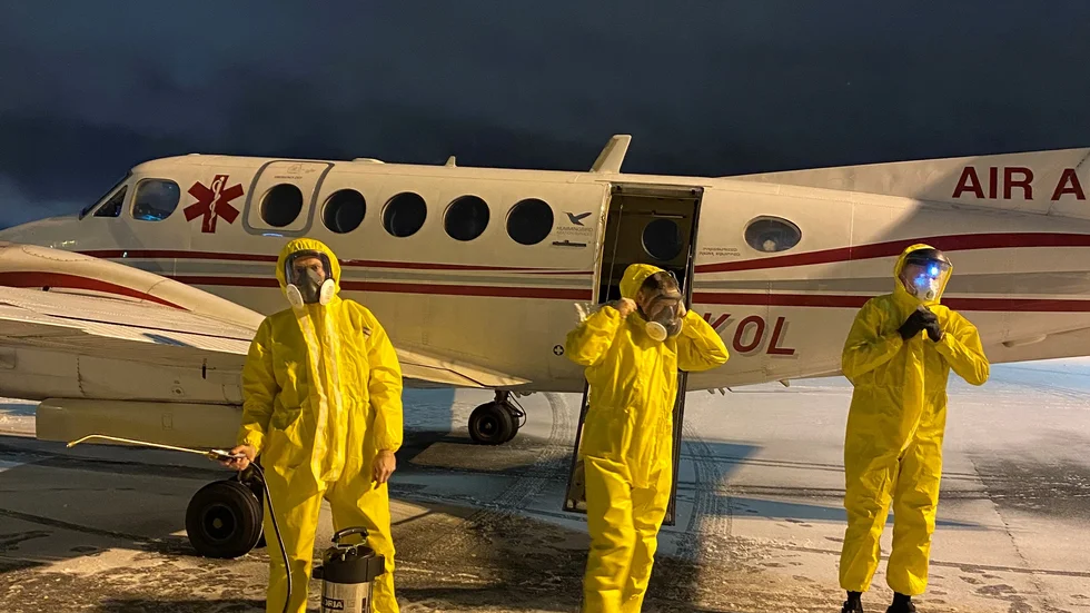 Robin Lindekrantz Ählman och Henrik Ekdahl, piloter, och Jerry Thörne, narkossköterska, i full skyddsutrustning för att transportera covid-patienter.
