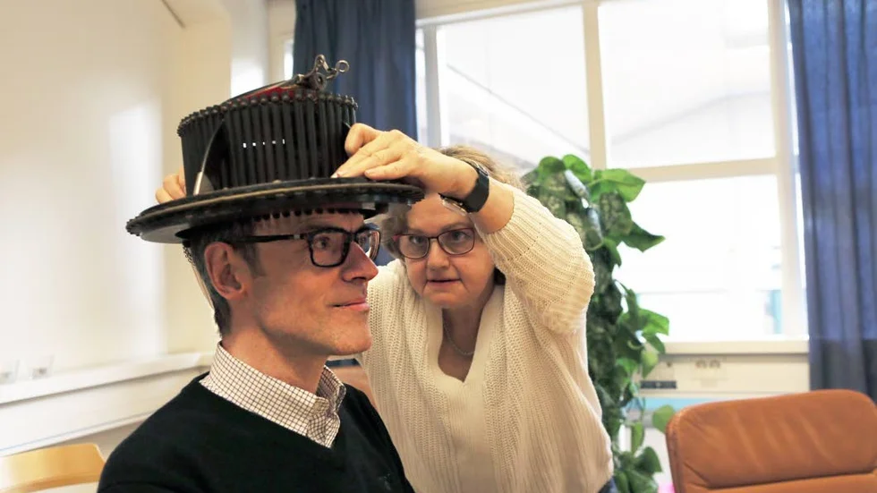 Mäter. Ulf Melin, till vardags chef för avdelningen Informatik på Institutionen för ekonomisk och industriell utveckling, får sitt huvud mätt av hattmakaren Marie Fredsberg.