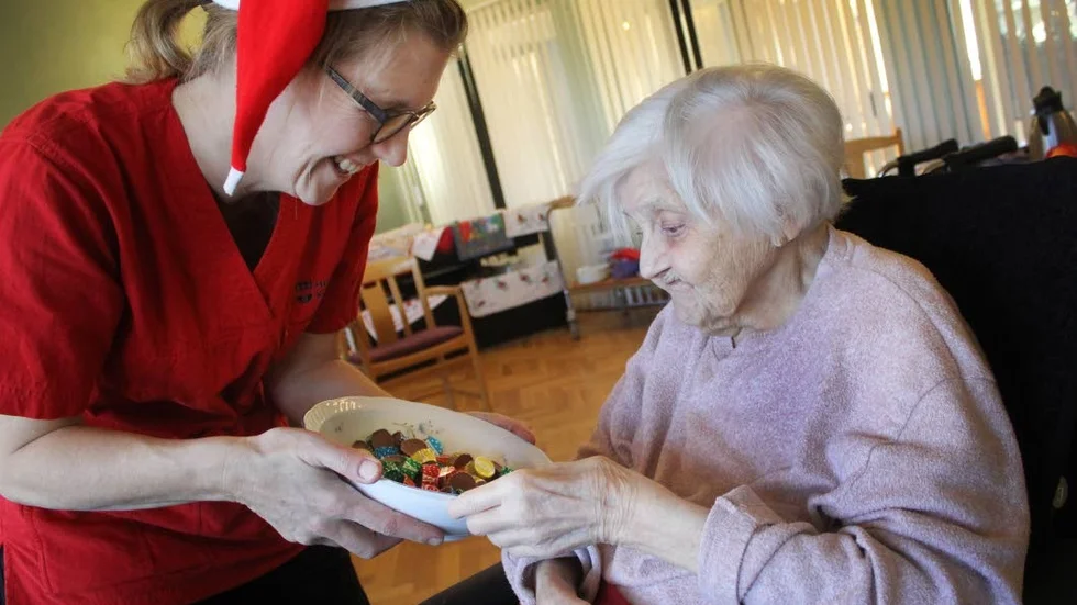 Marlies Verheggen bjuder Karin Britsner på choklad i blankt papper. Samtidigt passar hon på att påminna om färgerna som omslagspapperet har. "Du valde en grön", säger Marlies Verheggen.