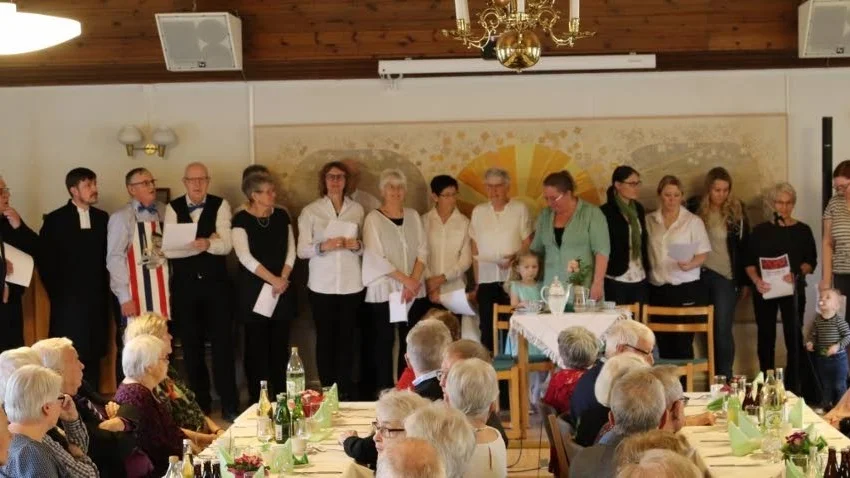 Bygdeborna ställer upp för att göra det lite festligt för andra sockenbor. Serverings- och kökspersonalen bidrog även med sång.