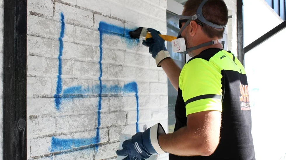 Skadegörelse. På det vita områdeskontoret på Ekön har någon sprayat fem hakkors med en blå färg.