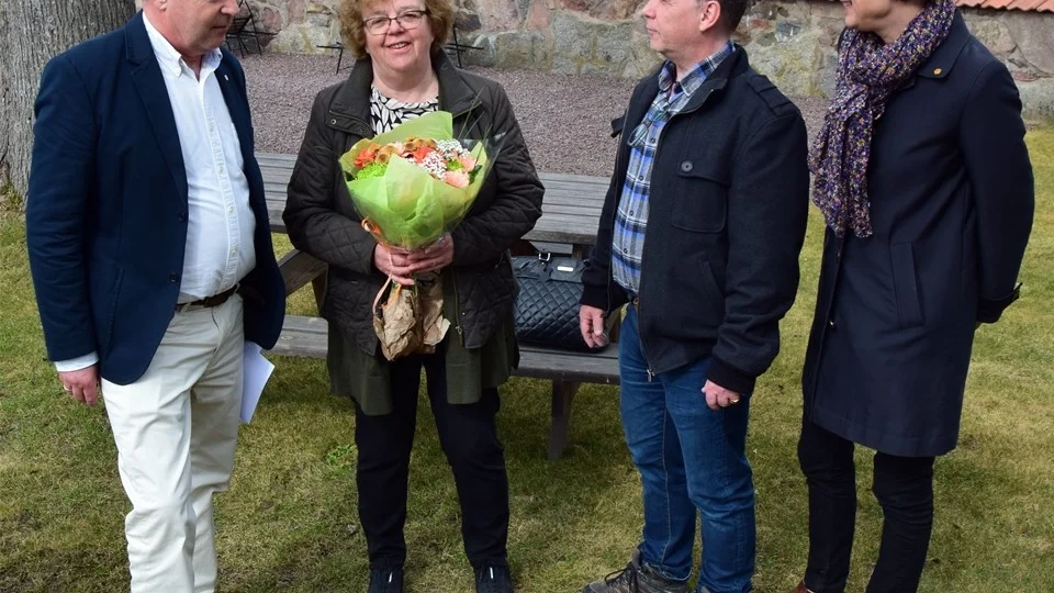 Björn Hoflund, Conny Forsberg och Karin Dahmén från samhällsbyggnadsnämnden gratulerade Gerd Pettersson, representant för föreningen "Kisa allsång till Bertil Nilssons minne". Foto: Morgan Karlsson