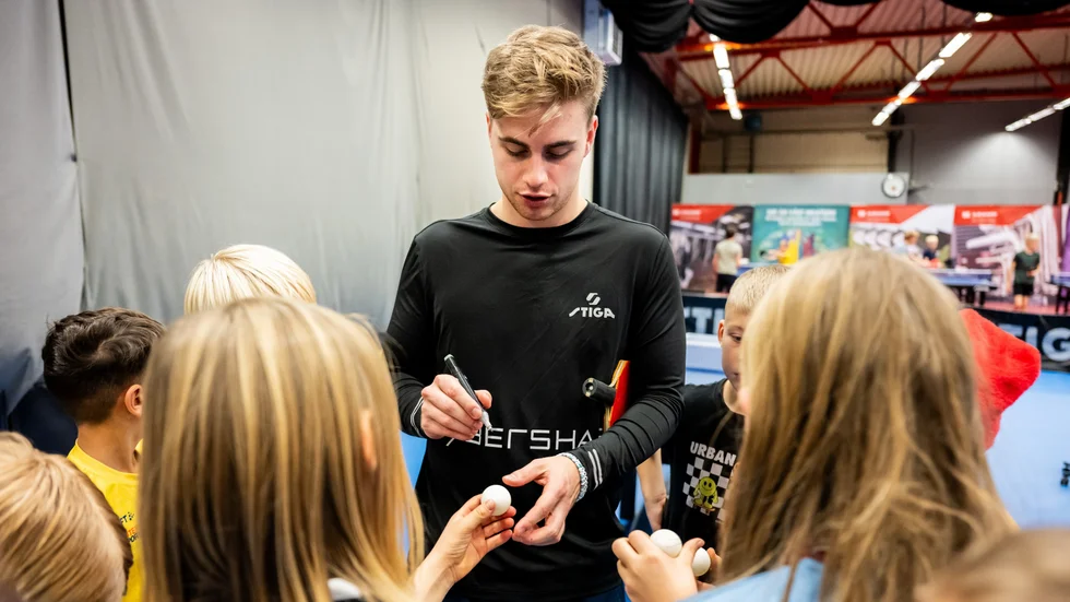 Truls Möregårdh skriver autografer efter en bordtennisträning med barn och ungdomar i Eslöv. 
