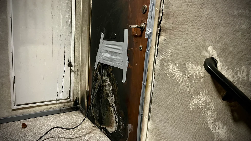 Lägenhetsdörrens utsida fick omfattande skador i samband med branden och en av polisens teorier är att gärningsmännen kastat brandfarlig vätska in genom brevinkastet.