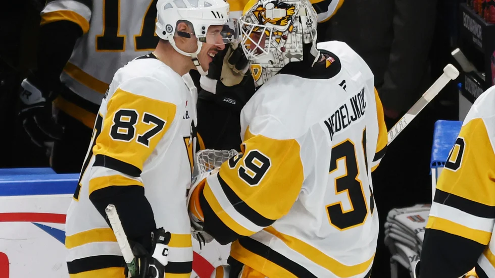 Pittsburghs målvakt Alex Nedeljkovic firar med lagkamraten Sidney Crosby efter vinsten mot Buffalo.