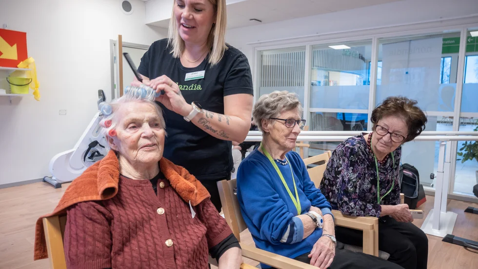 Jenny Rosengren, aktivitetsansvarig, rullar upp håret på Eva Forslund. Gerd Sundqvist och Britt-Mari Ahlman besöker också salongen för att göra sig i ordning för festen.