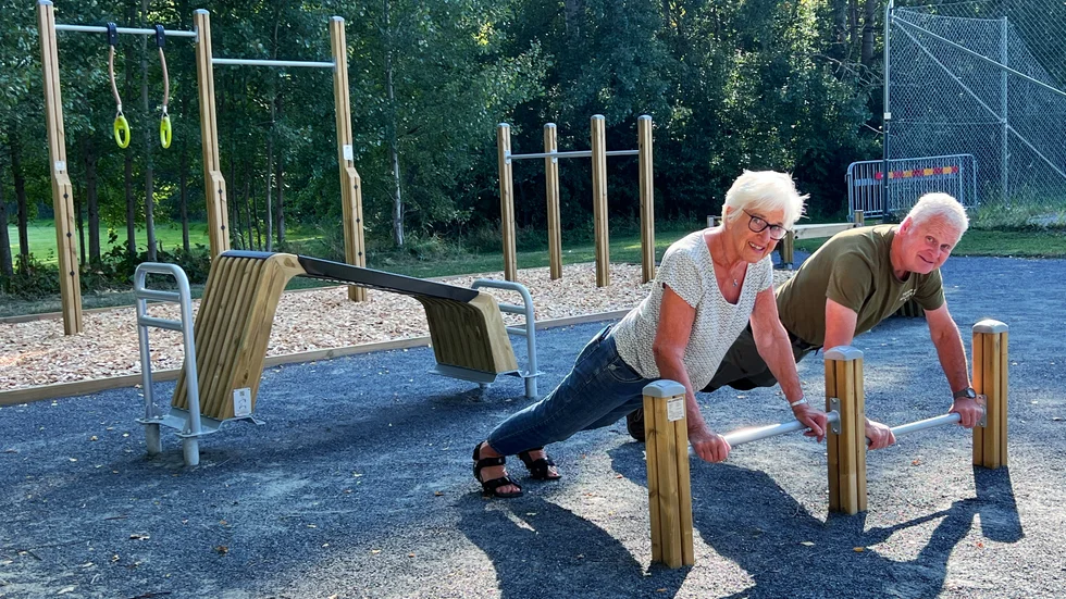 Eivor Folkesson och Kalle Wallin från Östgöta Dals förening testar de låga stängerna som bland annat passar för armhävningar, på utomhusgymmet i Borghamn.