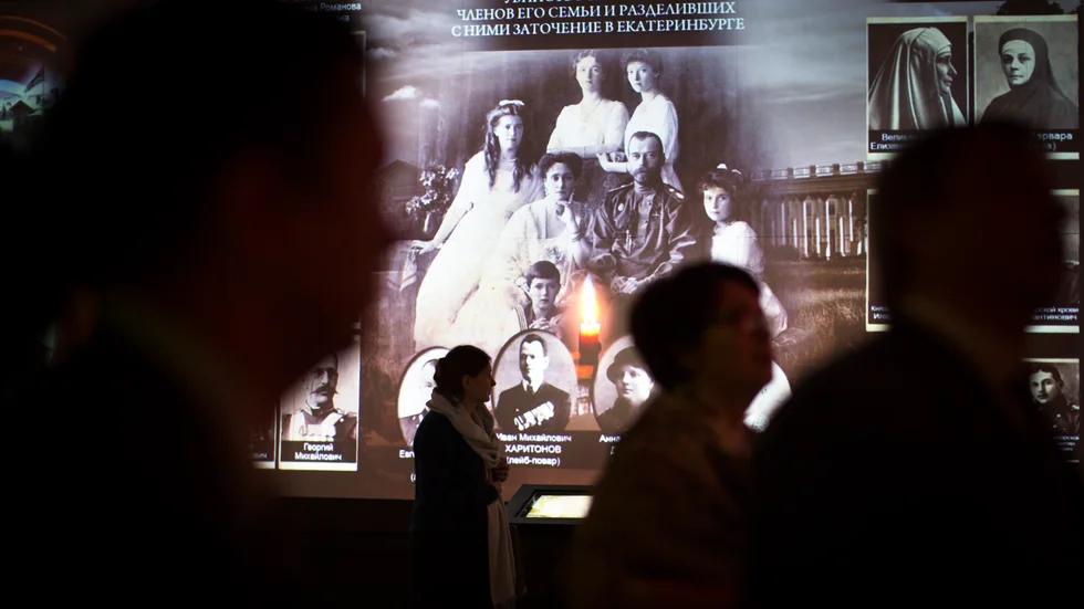 Besökare passerar ett foto på den sista ryska tsarfamiljen vid en historisk utställning i Moskva. Tsarinnan Alexandra sitter ned bredvid sin make, tsar Nikolaj II. Arkivbild.