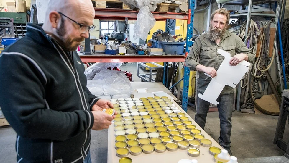 I ett litet företag med hantverksmässig tillverkning får man göra allt. Björn Kullman klistarar etiketter på burkarna under tiden som Johnny Persson viker kartonger att packa dem i.