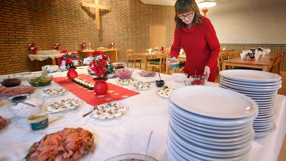 Miriam Holm fixar till det sista på serveringsbordet bakom ett berg med tallrikar.