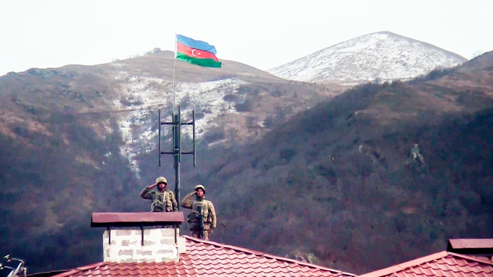 Azeriska soldater gör honnör sedan armén gått in i den övergivna staden Kalbajar, ett av de områden som Armenien lämnat över kontrollen av. Bilden kommer från azeriska försvarsdepartementet.