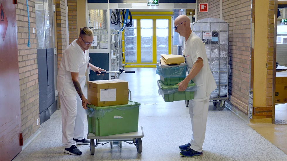Antti Kurvinen och Kent Karlén lastar en cykel för leverans till en av sjukhusets avdelningar.