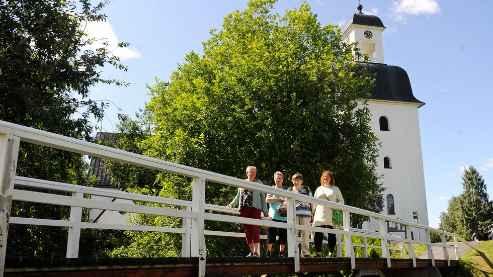 Ingabritt Johansson, Anette Lindfors, Rut Lindholm och Martina Lindberg på kyrkobron vid kyrkan i Kusmark. Platsen där sagan om kyrkoråttornas vandring startade.
