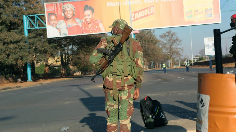 En soldat bevakar en folktom gata i Harare på fredagen.