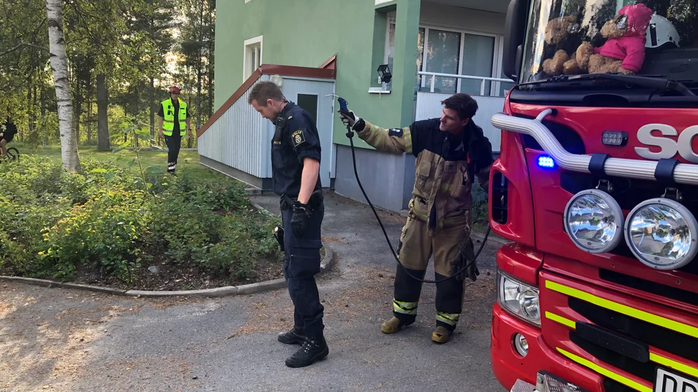 Poliserna som släckte branden fick släckningspulver på sig och får hjälp att blåsa rent.