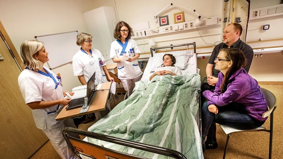 Överlämning. Nina Wallin (till vänster), sjuksköterska, lämnar övert till Karin Lindahl, undersköterska, och Liselott Pettersson, sjuksköterska, i nästa skift. 11-årige Hjalmar lyssnar tillsammans med föräldrarna Anne och Henrik Lindmark.