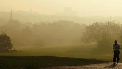 En man joggar på Parliament Hill i ett dimmigt London.