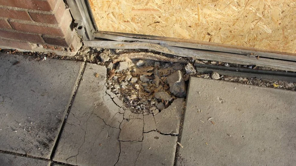 Vid explosionen, som skedde vid en entrédörr till socialkontoret, uppstod ett hål i en cementplatta.