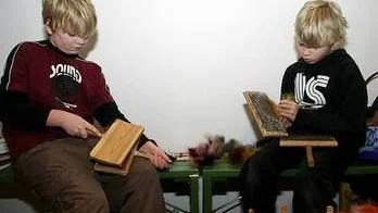 Adrian Lagerlöf och Daniel Ljungberg provar på att karda.