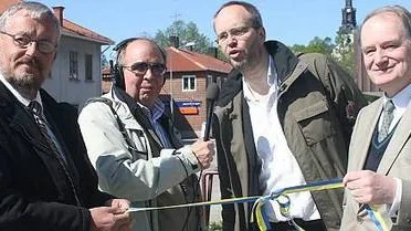 Kommunfullmäktiges ordförande Gösta Persson (till vänster) och landshövning Anders Björk gjorde med gemensamma krafter en symbolisk knut för att visa att två nya radiomaster, i Morgongåva och Tärnsjö, tagits i bruk. Bakom intervjuas Radio Upplands kanalchef Andreas Miller av Bengt Götegård, reporter vid radiostationen.	Foto: Johan Eriksson