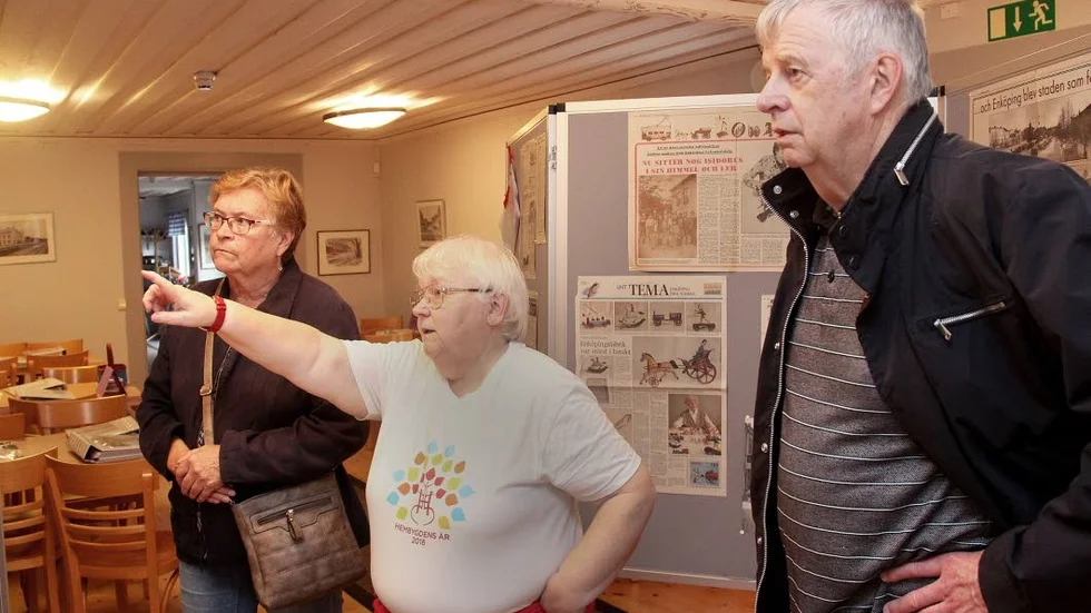 Anna-Lena Eriksson, ordförande i Enköpings stads hembygdsförening, berättar var de olika fotografierna från centrum är tagna för Ros-Marie och Gunder Brandell.