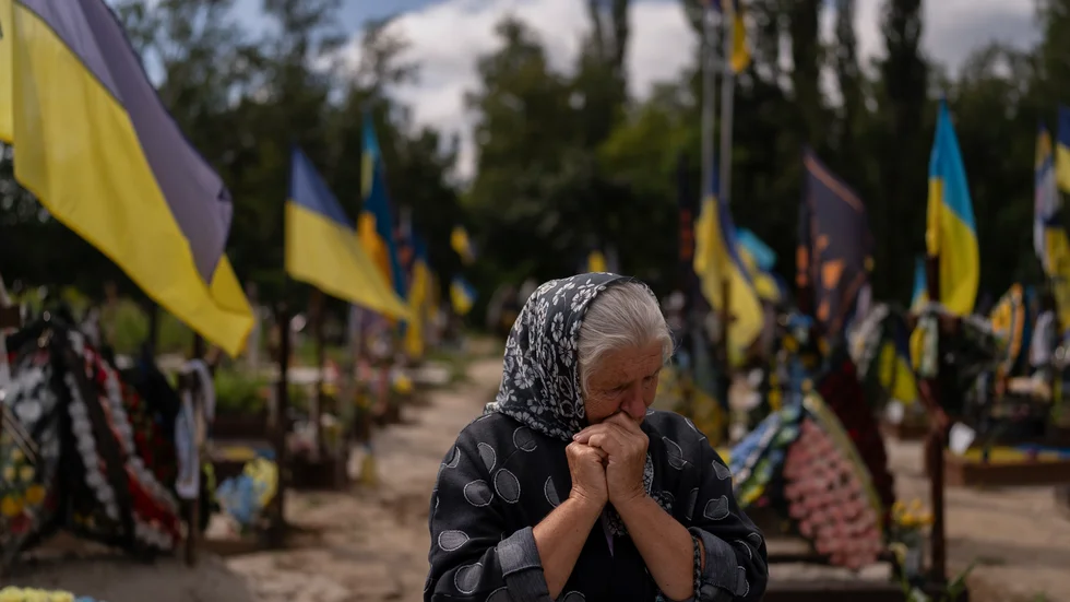 En ukrainsk kvinna besöker sin sons grav i Ukraina. Han dödades i kriget förra året.