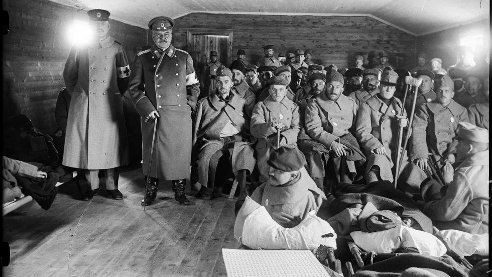 Krigsskadade, Röda Kors-personal och läkare väntar på att stiga i land från Röda Korsets pråm någon gång mellan 1914-1918. Längst till vänster ses den svenske intendenten för Röda Korset Östling, bredvid honom den ryske generalen Schuvaloff.
