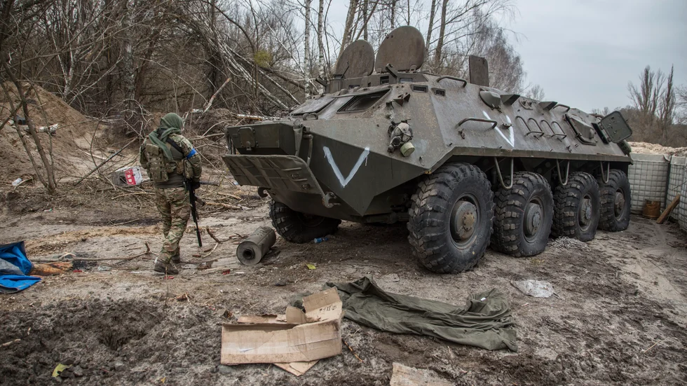 En ukrainsk soldat passerar ett övergivet ryskt pansarfordon i närheten av Tjernobyl.