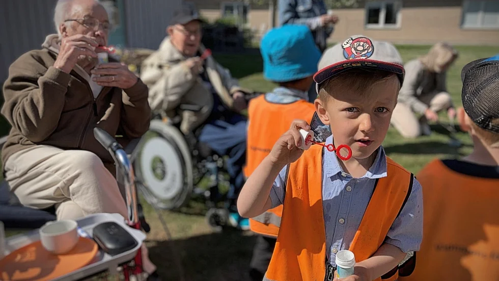 Rasmus Ivarsson, 6, blåser såpbubblor med de boende på Karl-Johansgården i Svartbäcken.